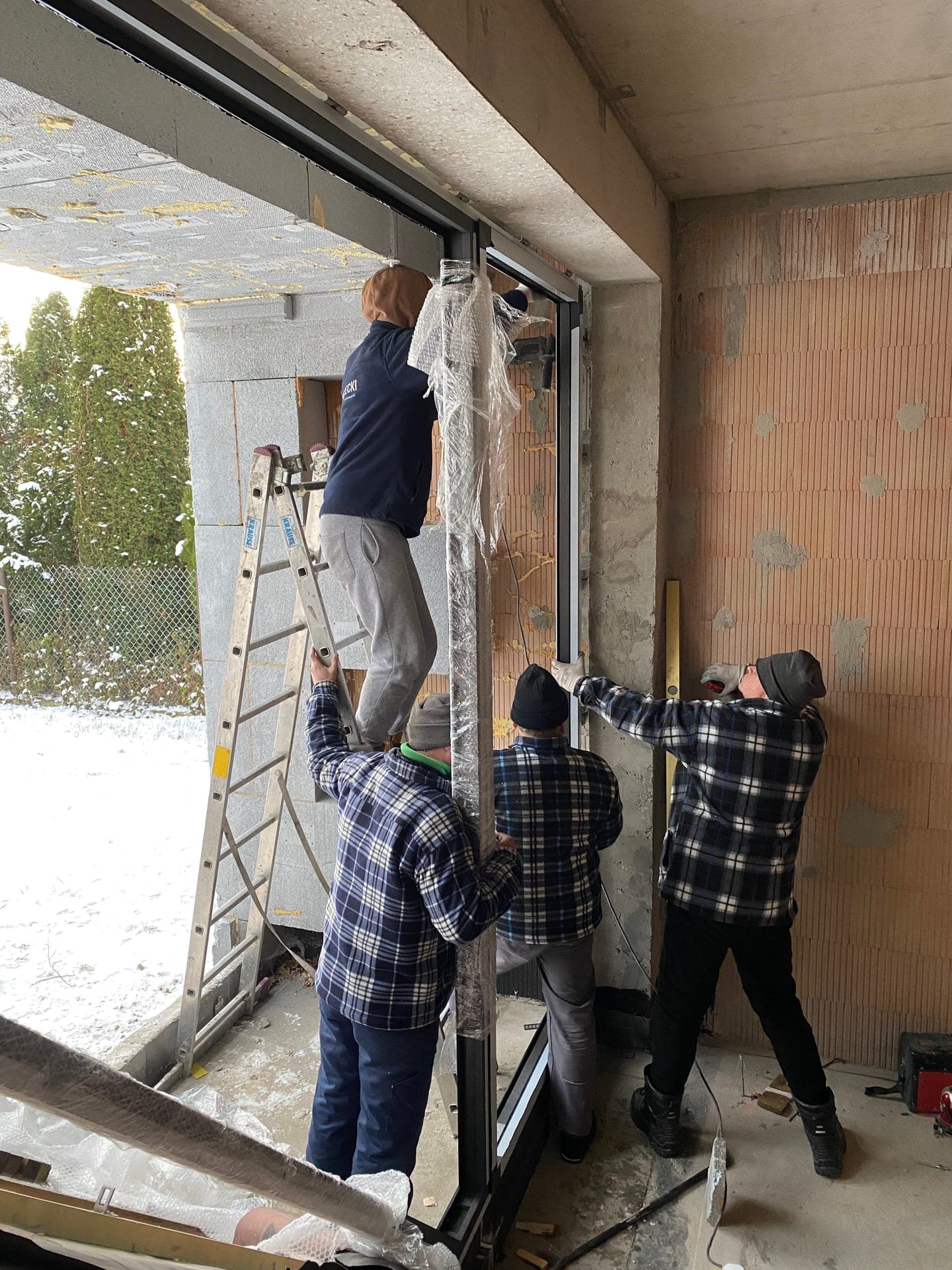 Three-man crew installing a large sliding door in a private home