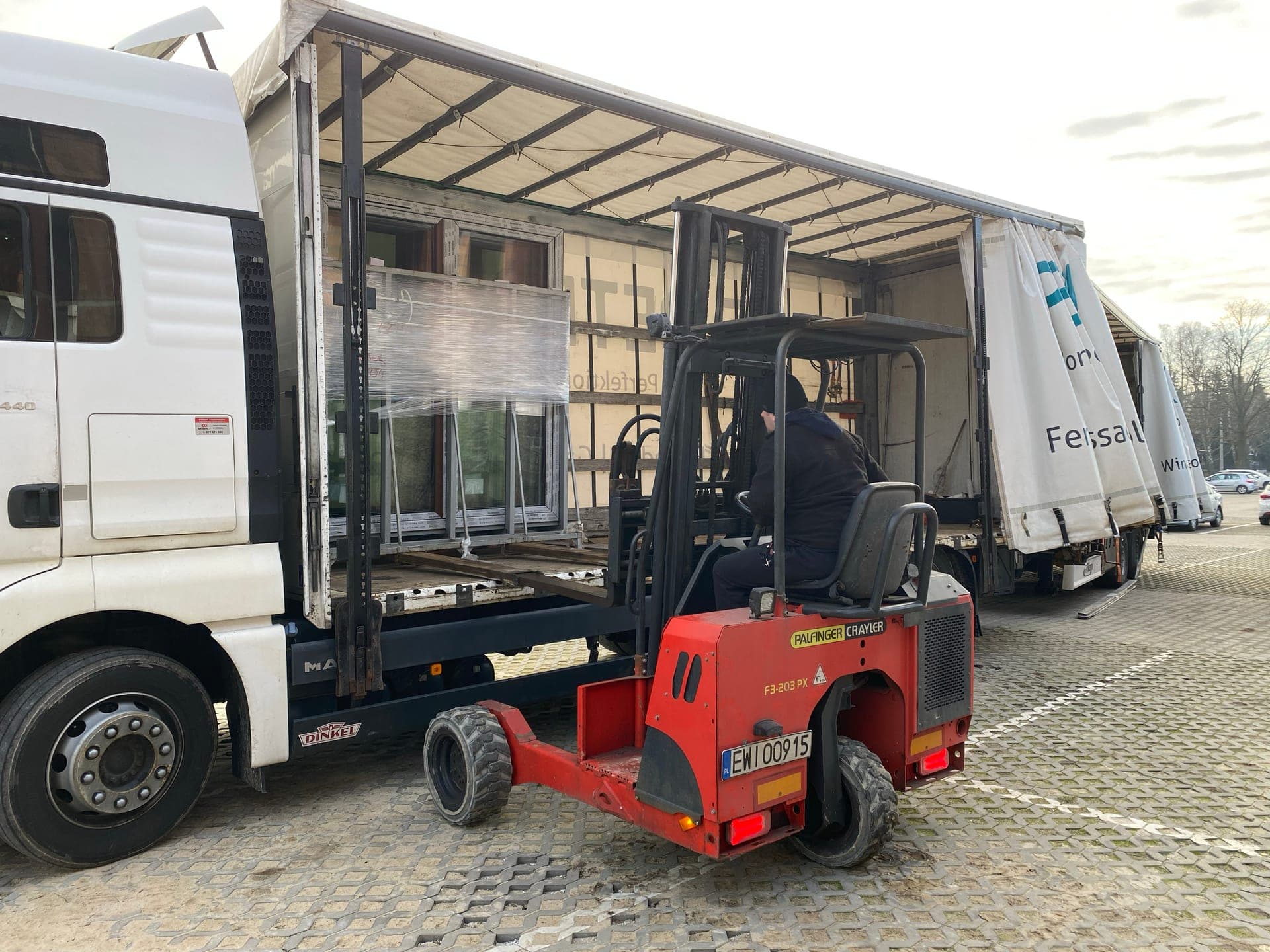 Forklift unloading window packages from a delivery truck