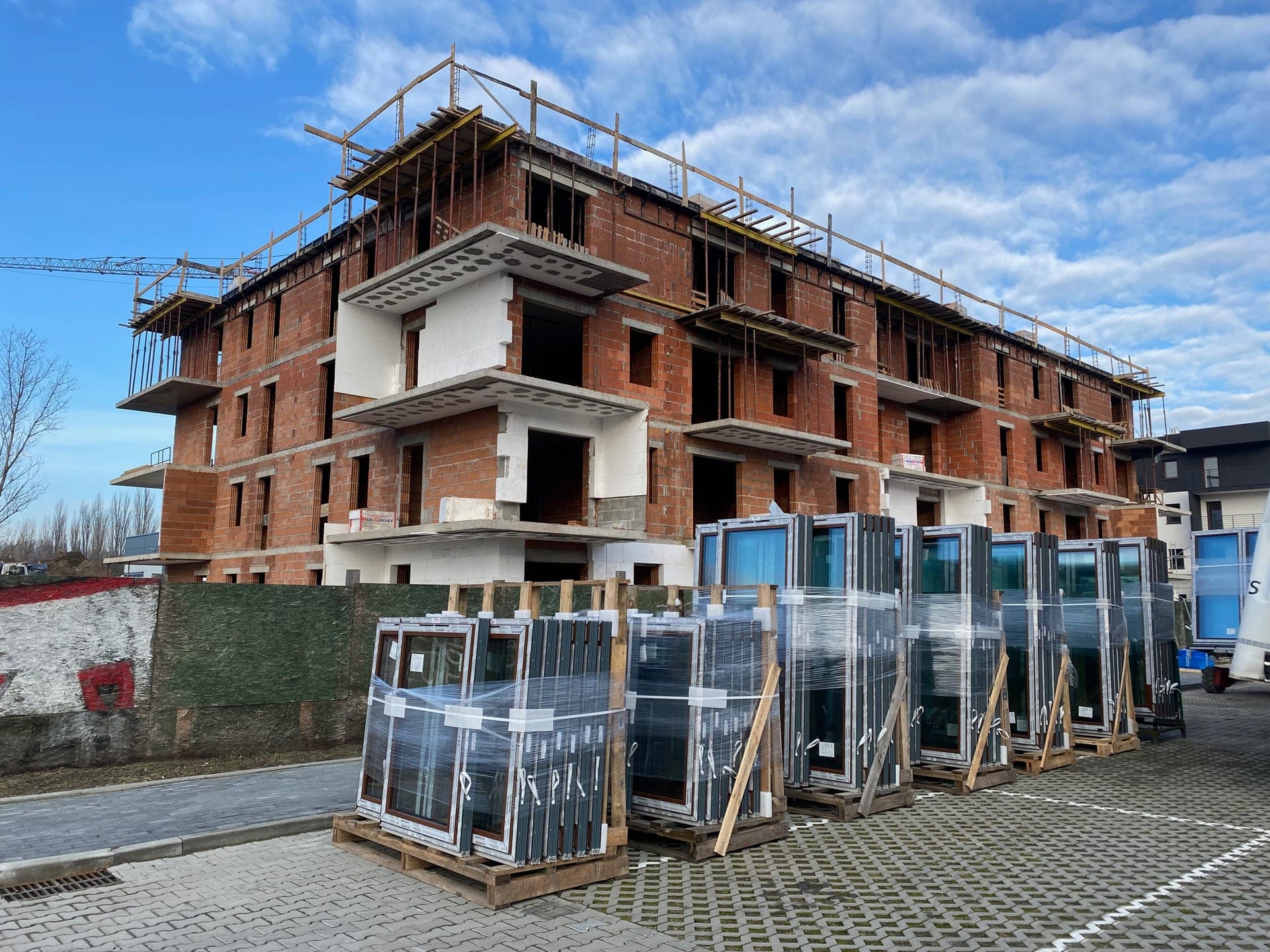 Window packages on pallets ready for installation at a multi-story apartment complex